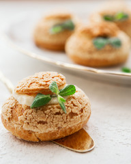 Homemade profiteroles on the music sheet with notes. Profiteroles (choux à la crème) - French choux pastry balls filled with custard or cottage cheese