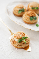 Homemade profiteroles on the music sheet with notes. Profiteroles (choux à la crème) - French choux pastry balls filled with custard or cottage cheese