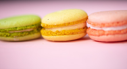 Multicolored macaroons on pink background.