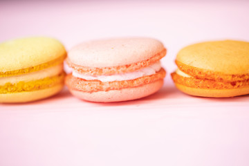 Multicolored macaroons on pink background.