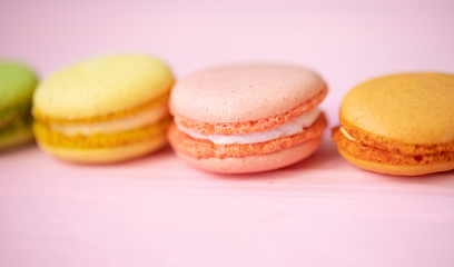 Multicolored macaroons on pink background.