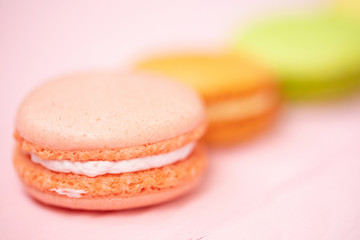 Multicolored macaroons on pink background.