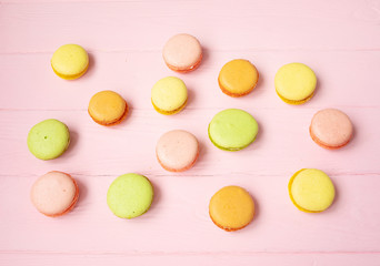 Multicolored macaroons on pink background.