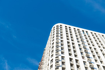 Modern new multi-storey residential building against the blue sky. business card concept