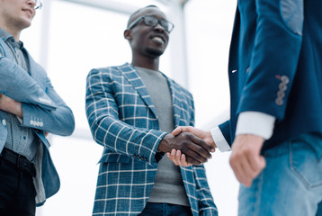 bottom view.young businessman shaking hands with his business partner