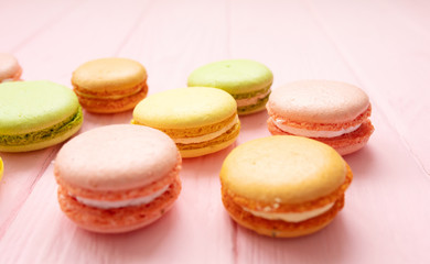 Multicolored macaroons on pink background.