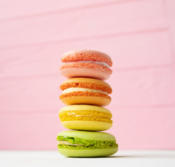 Multicolored macaroons on pink background.