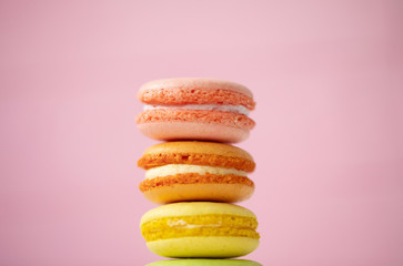 Multicolored macaroons on pink background.