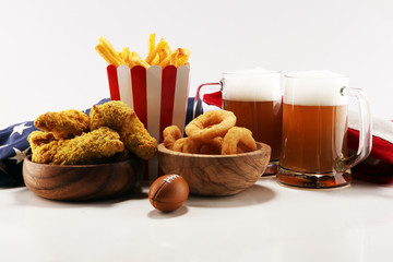 chicken wings, fries and onion rings for football on a table. Great for Bowl Game