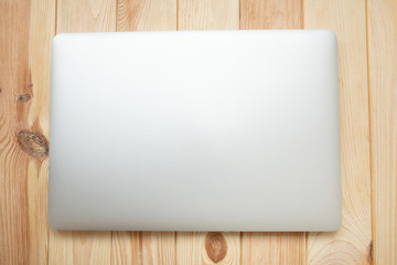 Closed laptop on a wooden background 