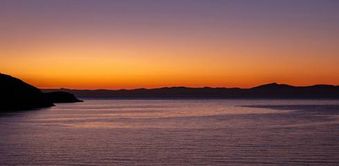 Aegean sea view from Kea island, Greece at sunset time, clear orange color sky background