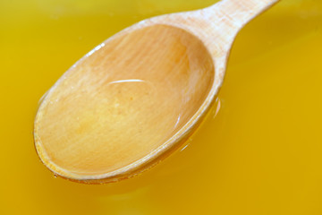 Wooden spoon in fresh liquid honey