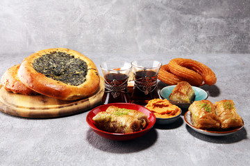 Middle eastern or arabic dishes and assorted meze, concrete rustic background. sambusak. Turkish Dessert Baklava with pistachio. Halal food.