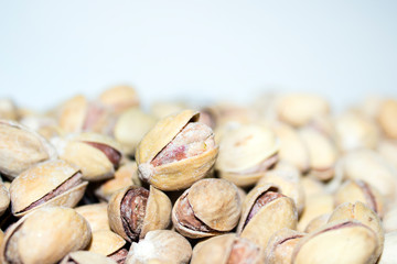 Roasted and salted pistachios in shell. Partial focus. Food background.