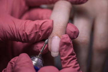 manicure process, machining, cuticle cut, red gloves, cleanliness and attention to hygiene
