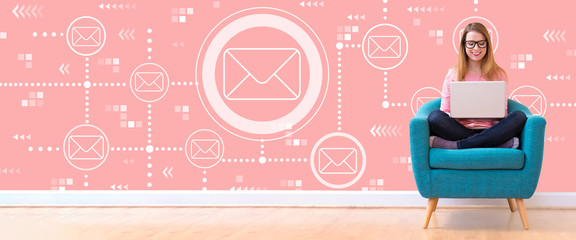 Emails with young woman using her laptop in a chair