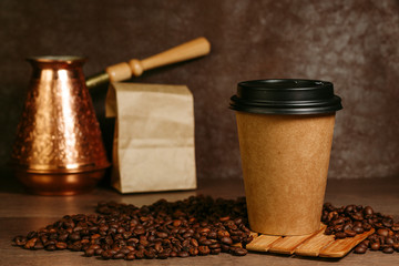 Paper cup with coffee on a wooden surface