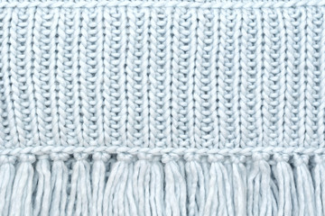 The texture of the knitted wool fabric from the front loops with fringe.