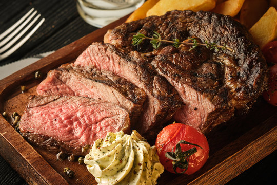 Juicy steak with fragrant butter. Sliced Ribeye Steak with Potatoes, Onions and Baked Cherry Tomatoes