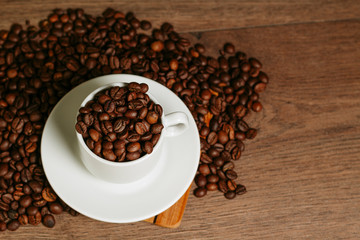 Cup with coffee beans on a wooden surface