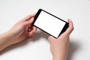 Two hands holding black smartphone on white background