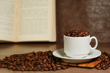 Cup with coffee beans on a wooden surface