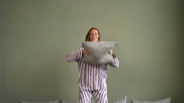 Gorgeous Woman Holding Throw Pillow While Jumping