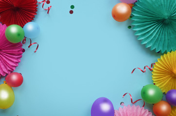 Paper texture flowers with confetti and baloons on blue background. Birthday, holiday or party background. Flat lay style.