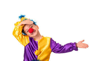 Studio shot of a little boy wearing carnival costume of a clown with a red round nose, isolate. He gesticulates with his hands showing what kind of hero he is.