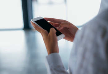 Woman hands using a smartphone read and text messages with blank space screen display- woman office worker- digital and communication concept