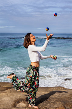 woman juggling by the ocean