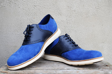 Dark blue sneakers with a white sole on a wooden background
