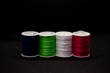 Colourful thread spools on a black background