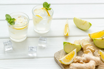 healthy drinks with apple and lemon for summer on white wooden background