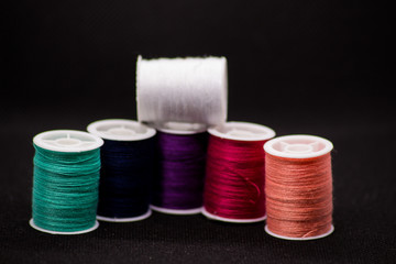 Colourful thread spools on a black background