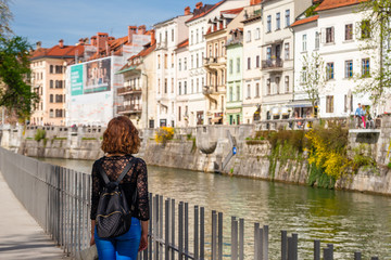 Fototapeta na wymiar Young woman is admiring old buildings and apartments in old part of Ljubljana, Slovenia
