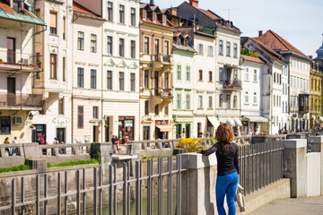 Young woman is admiring old buildings and apartments in old part of Ljubljana, Slovenia