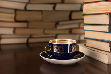 cup of tea and many books on the desktop