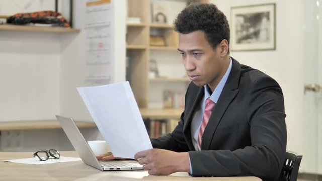 African Businessman Reading New Contract at Work