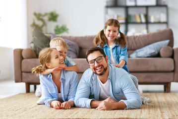 happy family mother father and kids at home on couch