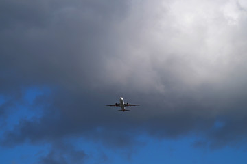 Flugzeug in der Luft unterfliegt Regenwolke - Stockfoto