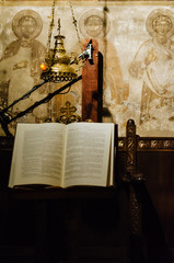 A psalter stand inside a church with some iconography in the background