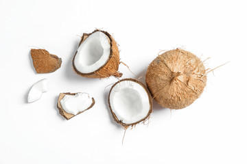 Two coconut one of which split on white background - obrazy, fototapety, plakaty