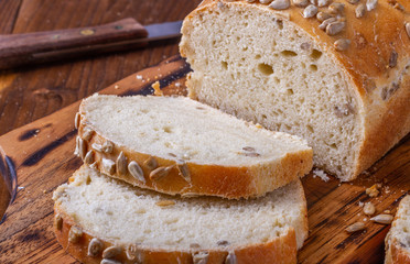 Domowy chleb bezglutenowy na desce do krojenia pokrojony na kromki.