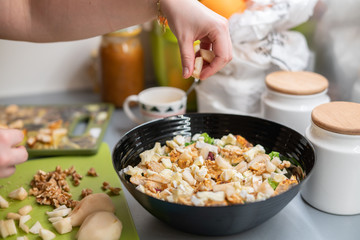 Woman prepares a salad with chicken.