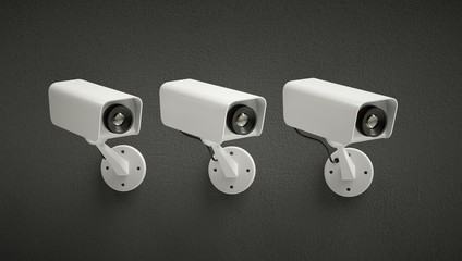 Three security cameras watching the same point. Dark background.