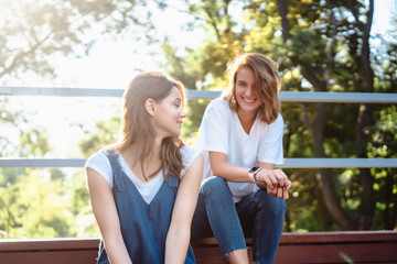 Two beautiful young woman resting on a bench