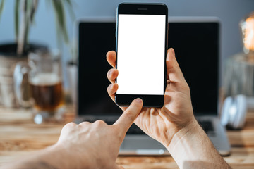 Man hands holding smartphone with blank white screen