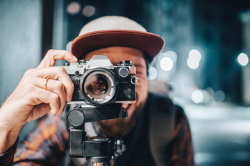 Man taking photo on vintage film camera - obrazy, fototapety, plakaty