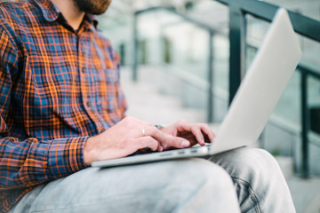 Young bearded freelancer working outside